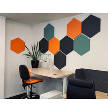 Load image into Gallery viewer, Office space with desk and chair. multi coloured acoustic hexagon tiles stuck to the wall to reduce noise
