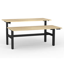Load image into Gallery viewer, Double sided electric sit/stand desk with 2 desks at different heights to illustrate they work separately